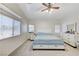 Bright main bedroom featuring plush carpeting, ceiling fan, and large windows at 8250 Lincoln Valley St, Las Vegas, NV 89123