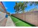 View of the home's side yard featuring artificial grass and a block wall fence at 8250 Lincoln Valley St, Las Vegas, NV 89123