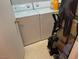 Laundry area with stacked washer and dryer units and cleaning supplies for convenience at 8250 N Grand Canyon Dr # 2154, Las Vegas, NV 89166
