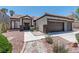 Charming single-story home featuring a well-manicured front yard with desert landscaping and a two-car garage at 8847 W Katie Ave, Las Vegas, NV 89147