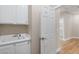 Bright laundry room with white cabinets, utility sink and access to the home's interior at 8847 W Katie Ave, Las Vegas, NV 89147