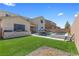 Expansive backyard with pool, spa, outdoor kitchen, and lush artificial turf at 8953 Hitch Creek St, Las Vegas, NV 89131