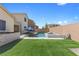 Spacious backyard featuring a pool, spa, outdoor kitchen, and well-maintained artificial turf at 8953 Hitch Creek St, Las Vegas, NV 89131