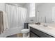 Bright bathroom featuring white fixtures, updated cabinets, shower with curtain, and a large mirror at 8953 Hitch Creek St, Las Vegas, NV 89131