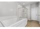 Bathroom featuring a tub and glass-enclosed shower with tiled walls and modern hardware at 8953 Hitch Creek St, Las Vegas, NV 89131
