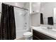 Cozy bathroom showcasing tub and shower, dark fixtures, white countertop, and decorative black shower curtain at 8953 Hitch Creek St, Las Vegas, NV 89131