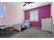 Bedroom features a purple accent wall, modern fixtures and plush carpeting at 8953 Hitch Creek St, Las Vegas, NV 89131