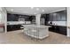 Modern kitchen with black cabinets, granite countertops, stainless steel appliances, and island seating at 8953 Hitch Creek St, Las Vegas, NV 89131