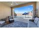 Covered patio with an outdoor seating area overlooking a large inground pool with a blue umbrella at 8953 Hitch Creek St, Las Vegas, NV 89131