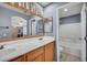Bathroom featuring double vanity, oak cabinets, and tub shower combo at 9165 Starling Wing Pl, Las Vegas, NV 89143