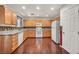 Bright kitchen boasting wood cabinets, granite countertops, white appliances, and hardwood floors at 9165 Starling Wing Pl, Las Vegas, NV 89143