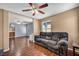 Cozy living room featuring hardwood floors, neutral walls, ceiling fan, and seamless access to a well-lit bathroom at 9165 Starling Wing Pl, Las Vegas, NV 89143