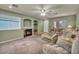 Bright living room features fireplace, built-in shelving, door, and picture window at 9165 Starling Wing Pl, Las Vegas, NV 89143