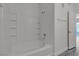 Bathroom with tub and shower combo with built in shelves, and grey wood-look flooring at 9330 W Maule Ave # 212, Las Vegas, NV 89148