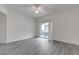 Open bedroom with sliding glass door leading to the outside patio, grey wood-look flooring, and ceiling fan at 9330 W Maule Ave # 212, Las Vegas, NV 89148