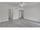 Large, bright bedroom with ceiling fan, grey wood-look flooring, and multiple doors at 9330 W Maule Ave # 212, Las Vegas, NV 89148