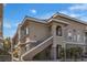 Exterior view of a tan two-story condo with stairs and well-maintained landscaping at 9330 W Maule Ave # 212, Las Vegas, NV 89148