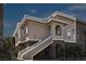 Exterior view of a tan two-story condo with stairs outlined in white at 9330 W Maule Ave # 212, Las Vegas, NV 89148