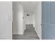 Hallway with neutral walls, gray wood floors, and a view into the living area, showcasing a clean and bright interior at 9330 W Maule Ave # 212, Las Vegas, NV 89148