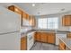 Bright kitchen featuring wooden cabinets, white appliances, gray countertops, and a window over the sink at 9330 W Maule Ave # 212, Las Vegas, NV 89148