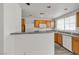 Bright kitchen featuring wooden cabinets, white appliances, gray countertops, and a view into the dining area at 9330 W Maule Ave # 212, Las Vegas, NV 89148