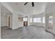 Bright, open-concept living room with gray wood floors, large windows, and a view into the connected kitchen at 9330 W Maule Ave # 212, Las Vegas, NV 89148