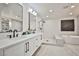 Modern bathroom featuring dual sinks, soaker tub, and tiled walk-in shower at 9340 W Washburn Rd, Las Vegas, NV 89149