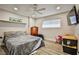 Neutral bedroom featuring a ceiling fan, tv, and wood-look floors at 9340 W Washburn Rd, Las Vegas, NV 89149