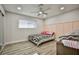 Bright bedroom featuring board and batten accent wall, ceiling fan, and wood-look flooring at 9340 W Washburn Rd, Las Vegas, NV 89149