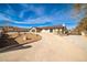 Single-story home with an extra long driveway, an attached garage, neutral colors, and desert landscaping at 9340 W Washburn Rd, Las Vegas, NV 89149