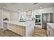 Bright and modern kitchen with quartz countertops, a central island, stainless steel appliances, and wood-look flooring at 9340 W Washburn Rd, Las Vegas, NV 89149