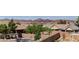 Backyard includes mature trees, a swimming pool, and privacy fence with mountain views in the background at 952 Crescent Falls St, Henderson, NV 89011