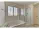 Bright bathroom featuring a soaking tub and a glass-enclosed shower with bright natural light at 952 Crescent Falls St, Henderson, NV 89011