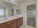 Bathroom featuring dual sinks and a large mirror, and an adjoining bedroom with a ceiling fan at 952 Crescent Falls St, Henderson, NV 89011