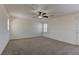 Spacious bedroom featuring neutral walls, ceiling fan, carpeting, and a glass door leading to outdoor space at 952 Crescent Falls St, Henderson, NV 89011