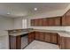 Well-lit kitchen featuring granite counters, wooden cabinets, stainless steel appliances, and tile flooring at 952 Crescent Falls St, Henderson, NV 89011