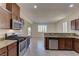 Stylish kitchen featuring stainless steel appliances, granite countertops, wooden cabinets, and tile flooring at 952 Crescent Falls St, Henderson, NV 89011