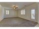 Bright living room featuring neutral walls, ceiling fan, carpeting, and a glass door leading to outdoor space at 952 Crescent Falls St, Henderson, NV 89011
