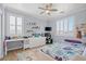 Bright bedroom with a ceiling fan, shutters, and a colorful accent rug at 9654 Ponderosa Skye Ct, Las Vegas, NV 89166