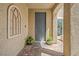 Cozy entryway with patterned brick flooring, potted plants, and a decorative arched window at 9654 Ponderosa Skye Ct, Las Vegas, NV 89166