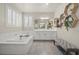 A bright bathroom with double sinks, soaking tub, walk in shower, and hexagon shelving at 9654 Ponderosa Skye Ct, Las Vegas, NV 89166