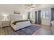 This main bedroom features a tufted headboard, ceiling fan and shuttered windows at 9654 Ponderosa Skye Ct, Las Vegas, NV 89166
