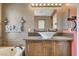 Charming bathroom featuring a vessel sink, wood vanity, modern lighting, and a soaking tub at 9931 Cherry Melee Ave, Las Vegas, NV 89148