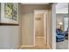 Hallway that leads into a sitting room and a half bathroom that reads 