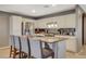 Close-up of a kitchen island with bar seating, granite countertops, stainless steel appliances, and white cabinetry at 9931 Cherry Melee Ave, Las Vegas, NV 89148