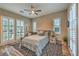 Bright bedroom with large windows, shutters, ceiling fan, and patterned rug at 10149 Terrastone Dr, Las Vegas, NV 89148