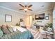 Comfortable bedroom featuring a ceiling fan, TV, fireplace, and patterned rug at 10149 Terrastone Dr, Las Vegas, NV 89148