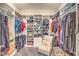 Organized walk-in closet with shelves, hanging rods, and seating area at 10149 Terrastone Dr, Las Vegas, NV 89148