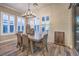 Dining room with wood-look floors, wainscoting, shuttered windows, modern chandelier and sliding glass doors at 10149 Terrastone Dr, Las Vegas, NV 89148