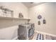 Well-lit laundry room equipped with a washer, dryer, and shelving at 10149 Terrastone Dr, Las Vegas, NV 89148
